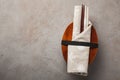 Closed wooden Japanese lunchbox with chopsticks, wrapped in a festive cloth on an old stone table. Top view with copy