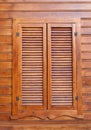 Closed wooden shutters on a wooden panneled wall