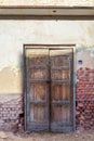 Closed abandoned wooden weathered door and shabby old grunge red bricks wall Royalty Free Stock Photo