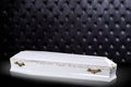 Closed wooden white coffin isolated on gray luxury background. casket, coffin on royal background. Royalty Free Stock Photo