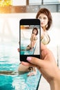 Closely image of female hands holding mobile phone with photo camera mode on the screen. Cropped image of beautiful long