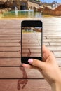 Closely image of female hands holding mobile phone with photo camera mode on the screen. Cropped image of footprints on
