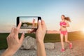 Closely image of female hands holding mobile phone with photo camera mode on the screen. Cropped image of running woman