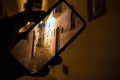 Closely image of hand holding mobile phone with photo of the night street in Asilah Medina, Morocco Atlantic Coast. Low