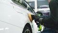 Closely shown as a professional worker polishes the transport car body using a polishing tool machine. Concept from: Auto serv