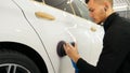 Closely shown as a professional worker polishes the transport car body using a polishing tool machine. Concept from: Auto serv