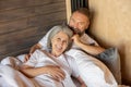 Mature couple staying in bed and feeling close and relaxed