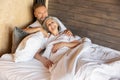 Mature couple staying in bed and feeling close and relaxed