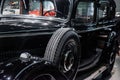 Closer look. Black antique shiny automobile with spare wheel on the side