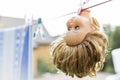 Closeup of abandoned broken doll head hanging on clothesline
