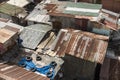 Closeup above view of slum houses with walls and roofs made of rusted sheet metal and pieces of leftover plywood