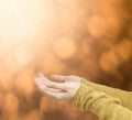 Closeup action of woman hold out hand to wait for good things on abstract blurred brown light spot bokeh textured background