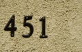 Closeup of an address number 451 on the rough surface of a wall Royalty Free Stock Photo