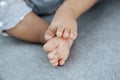 Closeup of adorable baby feet and tiny toes on soft grey blanket as a background