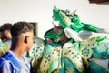 Closeup adult man in bright green costume walks by city street at dominican carnival