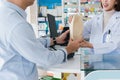 Closeup affable pharmacist hand qualified medicine to customer in pharmacy.