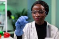 Closeup of african american biochemist woman holding green leaf sample Royalty Free Stock Photo