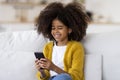 Closeup of african american little girl using smartphone at home Royalty Free Stock Photo
