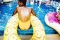 Closeup of african descent woman sitting by the pool with inflatable tubes