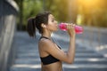 Closeup of fitness model drinking water during training at park