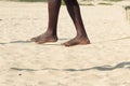 Closeup afro-american man feet walking on tightrope or slackline on sandy background. Slacklining is a practice in