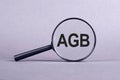 Closeup Of AGB Letters Under Magnifying Glass. German text AGB, translate General Terms and Conditions