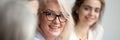 Closeup aged attractive smiling businesswoman listening colleague during briefing meeting