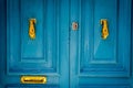 Closeup of an aged vibrant blue door with golden handlers Royalty Free Stock Photo