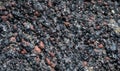 Closeup of aggregate rock of black volcanic rock and red rocks, as a nature background