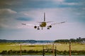 Closeup of an airplane flying over a field in the airport Royalty Free Stock Photo