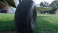 Closeup airplane wheel standing airfield grass. Plane chassis on green field.