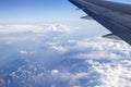 Closeup of an airplane wing flying on a beautiful cloud field Royalty Free Stock Photo