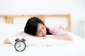 closeup alarm clock and beautiful asian young woman in morning