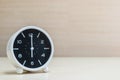 Closeup alarm clock for decorate in 6 o`clock on brown wood desk and wall textured background with copy space