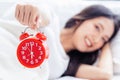 Closeup alarm clock has a nice day with happiness Young asian woman with smile face and healthiness background Beautiful girl hold