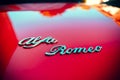 Closeup of the Alfa Romeo brand name on a red Alfa Romeo spider 1970