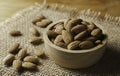 Closeup almonds in wooden bowl on sackcloth almond concept with copy space