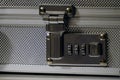 Closeup of an aluminum attache case lock placed on a white surface