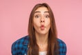 Closeup of amazed childish cute girl in checkered shirt standing with pout lips making fish face, having fun