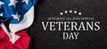 Closeup of American flag with Text Veterans Day Honoring All Who Served on black textured background. Royalty Free Stock Photo