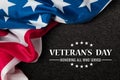 Closeup of American flag with Text Veterans Day Honoring All Who Served on black textured background. Royalty Free Stock Photo