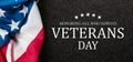 Closeup of American flag with Text Veterans Day Honoring All Who Served on black textured background. Royalty Free Stock Photo