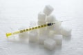 Closeup of amplty insulin syringe and pile of white sugar cubes on the white surface.Concept of metabolic disorders and special in