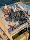 Closeup of an anchor, an iron chain and a starfish lying on a boat Royalty Free Stock Photo