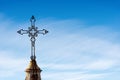 Christian cross in wrought iron on a blue sky with clouds - Bologna Italy Royalty Free Stock Photo