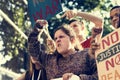 Closeup of angry teen girl protesting demonstration holding post