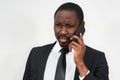 Closeup of angry young african man screaming while talking on smartphone over grey background Royalty Free Stock Photo