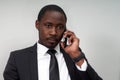 Closeup of angry young african man screaming while talking on smartphone over grey background Royalty Free Stock Photo