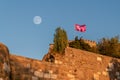 Closeup of Ankara Castle on blue sky background with flying flag under moon Royalty Free Stock Photo
