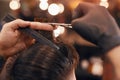 Crop hairstylist cutting hair of client in barbershop Royalty Free Stock Photo